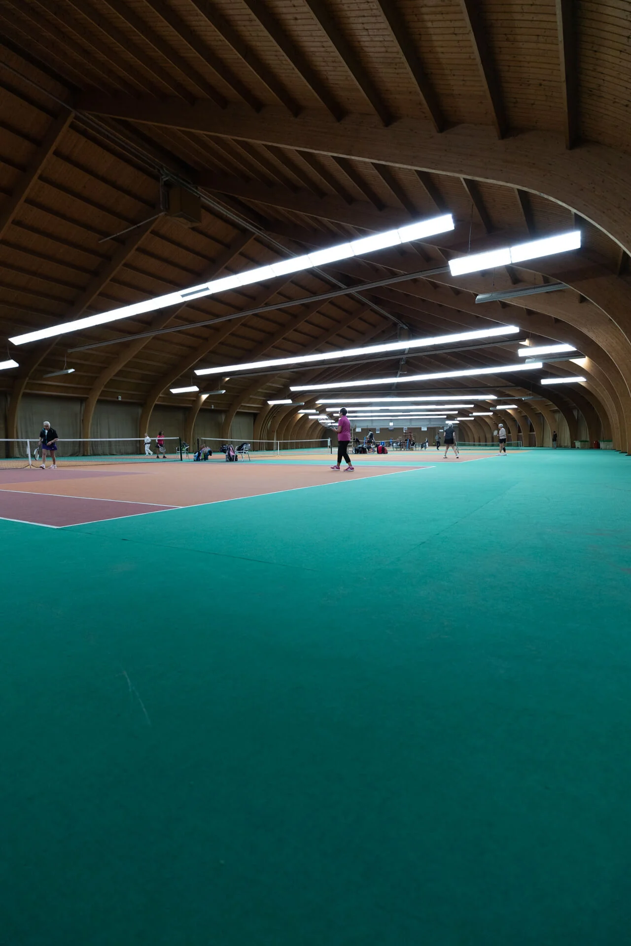 Vue panoramique du hall de tennis intérieur avec charpente en bois